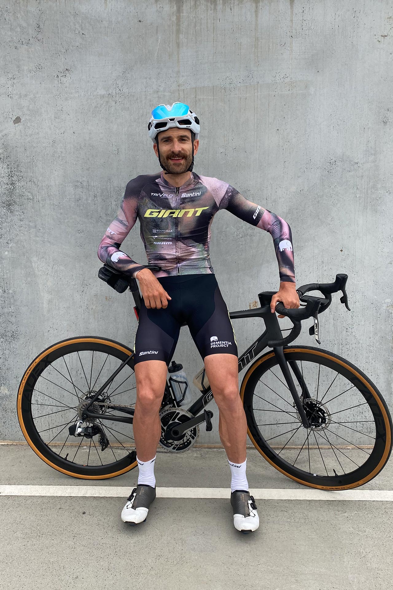 Nick Locandro sits on his bike for a portrait with a concrete background