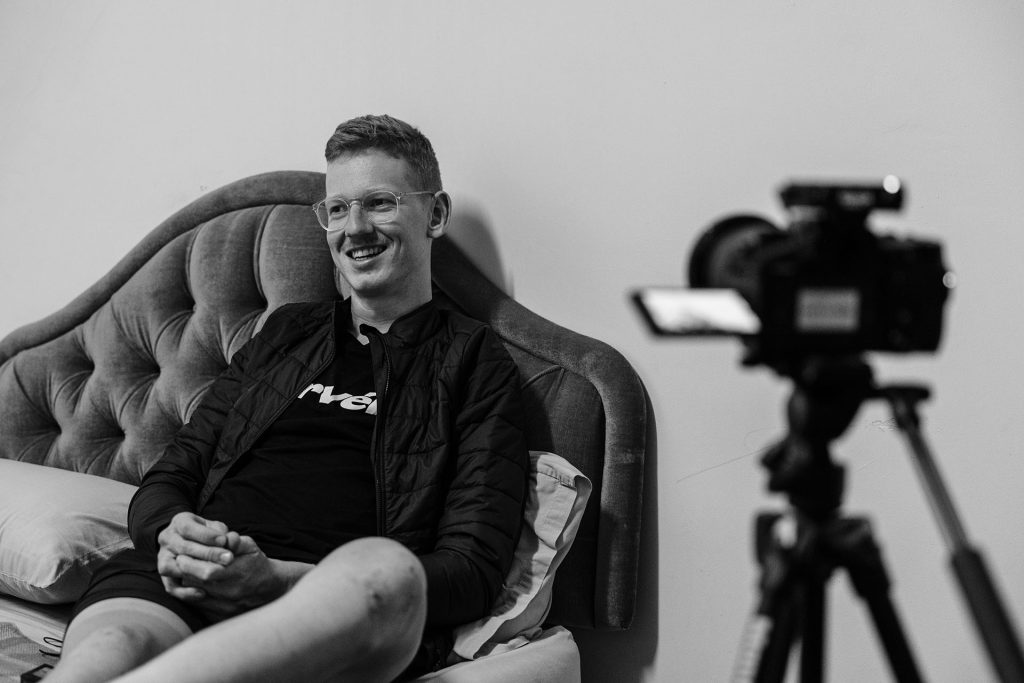 A black and white photo of Matt Bird sitting down with a camera pointed towards him.